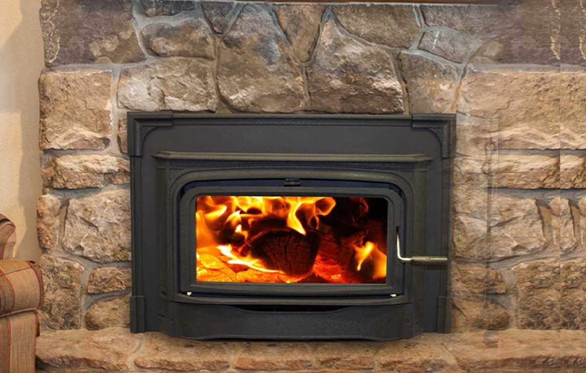 A wood insert set into a stone fireplace