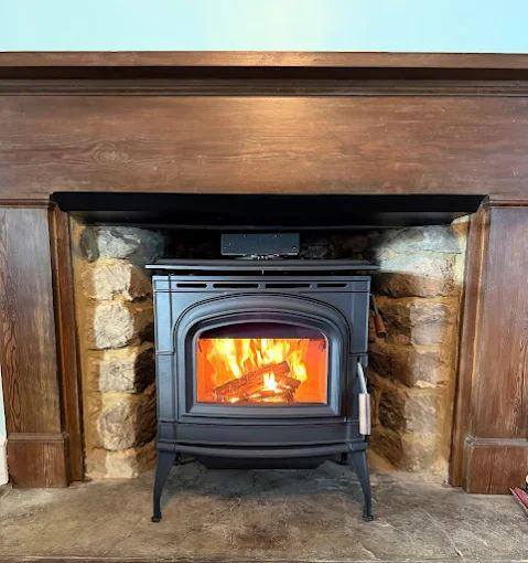 Wood stove set into a stone mantel